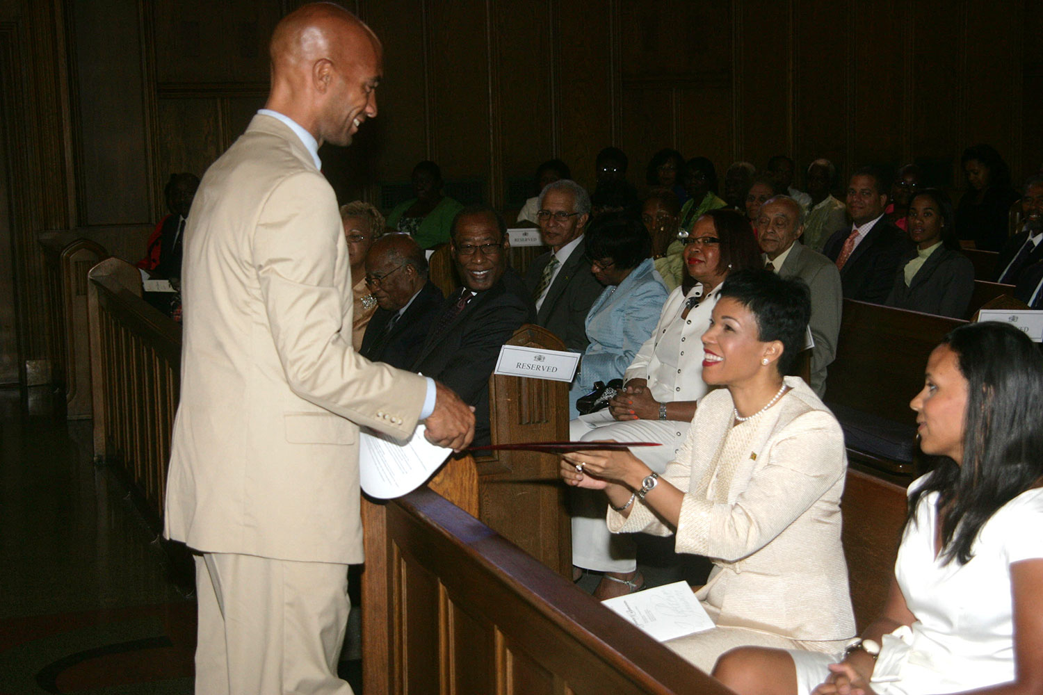 Jamaica’s ambassador to the United States, Her Excellency Audrey Marks (second left), accepts a scroll proclaiming August 6 as “Jamaica’s Independence Day in Washington DC,” from Washington DC former Mayor Adrian Fenty, during the Jamaican Independence Service of Thanksgiving at Howard University’s Dumbarton Chapel. At right in Mrs. Michelle Fenty 