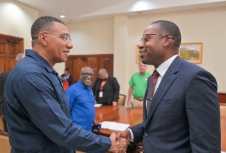 Prime Minister the Most. Hon. Andrew Holness (left), greets President and Chief Executive Officer the at Jamaica Public Service Company (JPS), Hugh Grant, during a meeting with the executive team of the JPS at the Office of the Prime Minister on Monday (August 5).

