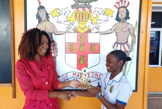 José Martí Technical High School student, Sanique Roberts (right), is presented with a trophy by Science teacher at the St. Catherine-based institution, Shanice Laing, for outstanding performance in academics and ports. The student is the recipient of the JMcKay Collection scholarship awarded by Jamaican-born registered nurse in the United States (US) and past student of the school,  Jillianne McKay Burrell. The scholarship will enable Sanique to pursue nursing studies at Northern Caribbean University (NCU).

