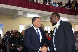 Prime Minister, Dr. the Most Hon. Andrew Holness (left), expresses condolences to sprint legend Usain Bolt at the funeral of the Olympian’s late father, Wellesley Bolt, at the Falmouth Seventh-day Adventist Church in Trelawny on May 4.

