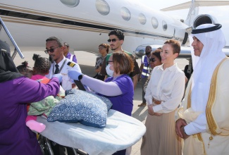 Minister of Foreign Affairs and Foreign Trade, Senator the Hon. Kamina Johnson Smith (second right), and Ambassador of the Kingdom of Saudi Arabia to Jamaica, His Excellency Dr. Waleed bin Abdulrahman Alhamoudi (right), observe as a flight crew prepares conjoined twins, Azora and Azaria Elson, to board a Medevac airplane at the Norman Manley International Airport in Kingston on Sunday (July 27), ahead of their departure to Saudi Arabia to undergo life-changing separation surgery. 

