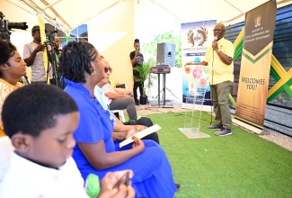 Minister of Local Government and Community Development, Hon. Desmond McKenzie (right), speaks during the handover ceremony for a furnished one-bedroom unit to Indigent Housing Programme beneficiary, Denise Chito, in Albion Meadows, St. Thomas, on Friday (July 25). The unit supplements a one-bedroom home Ms. Chito previously received under the New Social Housing Programme.