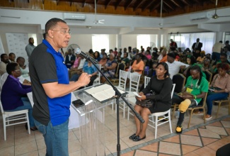 Prime Minister, Dr. the Hon. Andrew Holness (left) addresses a land title ceremony hosted by the Housing Agency of Jamaica (HAJ) at the Hotel Comingle in Savanna-la- Mar, Westmoreland on Friday ( July 18).