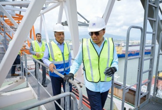 Prime Minister, Dr. the Most Hon. Andrew Holness (right), along with President and Chief Executive Officer of the Port Authority of Jamaica (PAJ), Professor Gordon Shirley (centre) and PAJ Chairman, Alok Jain, tours the facilities at Kingston Freeport Terminal Limited (KFTL), Port Bustamante, following the recent signing ceremony for the Westlands Expansion Project.

