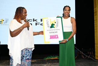 Black River Film Festival Creator, Dr. Ava Brown (left), makes a presentation to Public Relations and Communications Manager for the Jamaica Tourist Board (JTB), Fiona Fennel, during the recent staging of the Black River Film Festival held at Cloggy’s on The Beach in the St. Elizabeth capital.

