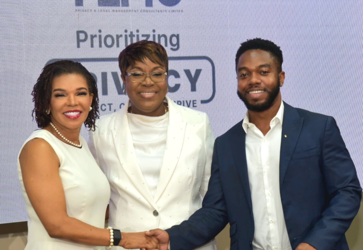 Minister without Portfolio in the Office of the Prime Minister with responsibility for Efficiency, Innovation, and Digital Transformation, Senator the Hon. Ambassador Audrey Marks (left), is greeted by Privacy and Legal Management Consultants (PLMC) Lead Compliance and Software Engineer, William Henlin (right), during PLMC’s Prioritising Privacy: Protect, Comply, Thrive conference, held at the University of the West Indies (UWI) Regional Headquarters in St. Andrew, on Tuesday (July 1). Sharing the moment is PLMC Managing Director, M. Georgia Gibson Henlin.