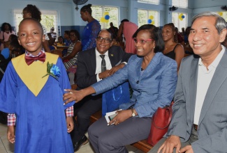 State Minister in the Ministry of Labour and Social Security, Dr. the Hon. Norman Dunn (seated left), Acting Permanent Secretary in the Ministry, Dione Jennings (centre), and United Nations Children’s Fund (UNICEF) Deputy Country Representative, Mohammad Mohiuddin, share a moment with Early Stimulation Programme (ESP) graduate, Suewayne Watson. The occasion was the ESP graduation ceremony, held at the Apostolic Church of Jamaica, Bethel Temple, in downtown Kingston on Wednesday (July 9).

