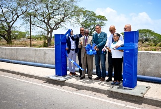 Prime Minister, Dr. the Most Hon. Andrew Holness (centre), cuts the ribbon for the recent handover of the over $326-million Myton Gully Drainage Improvement Project in Old Harbour, St. Catherine.  Sharing the moment (from left) are Managing Director of the Jamaica Social Investment Fund (JSIF), Omar Sweeney; Member of Parliament for St. Catherine South Western, Everald Warmington; Senior Environmental Specialist with the World Bank, Kirk Brown; and Custos of St. Catherine, Hon. Icylin M. Golding.


