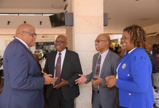 Postmaster General, Lincoln Allen (second right); Deputy Postmaster General, Business and Regional Operations, Sophia Hamilton-Brown, and Deputy Postmaster General, Corporate Base Operations, Carey Brown (second left), engage in discussion with Caribbean Postal Union Secretary General, Samuel Brangman. The interaction took place during the opening ceremony for the Small Island Developing States (SIDS) Postal Leaders Forum at the ROK Hotel in downtown Kingston on Tuesday (July 15).

