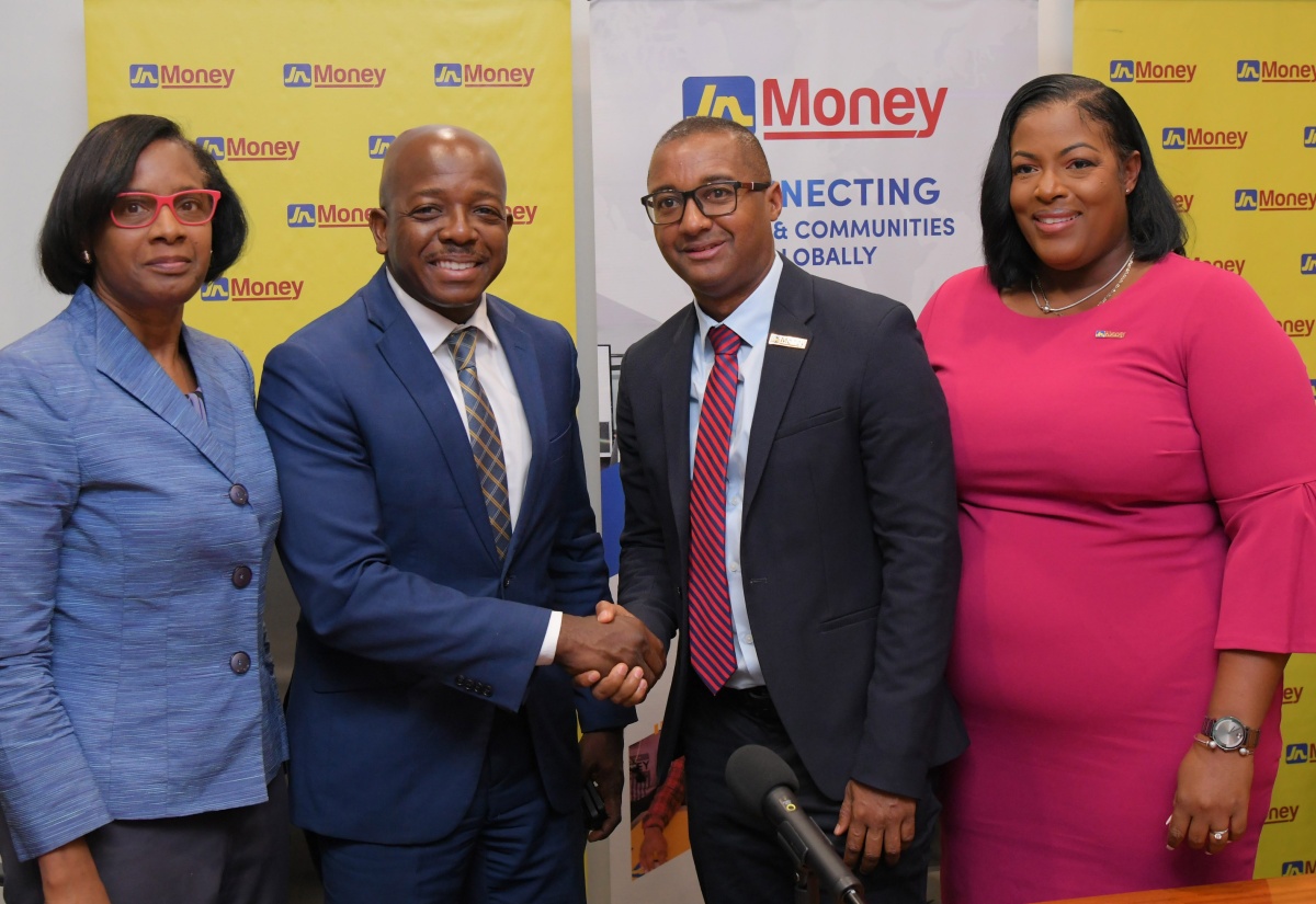 Minister of Labour and Social Security, Hon. Pearnel Charles Jr. (second left), shares a symbolic handshake with General Manager of JN Money Services, Horace Hines (third left), during Wednesday’s (July 9) launch of the Jamaica National (JN) Fields of Opportunity Scholarships, held at the JN Financial Centre on Belmont Road in Kingston. Sharing the moment (from left) are Acting Permanent Secretary in the Ministry, Dionne Jennings; and Assistant General Manager of JN Money Services, Sanya Wallace. 
