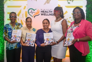 Director of Health Promotion and Protection in the Ministry of the Health and Wellness, Dr. Simone Spence (second right), joins in displaying the updated National Screening Guidelines for Priority Non-Communicable Diseases in Primary Health Care, at the launch of the document on Tuesday (July 29) at the Courtyard by Marriott in Kingston. From left are Non-Communicable Disease (NCD) Regional Coordinators in the Ministry – Dr. Beverly Wright, Dr. Micas Campbell Foreman, Dr. Kimberly Dunkley and Dr. Yasine Hanna.

