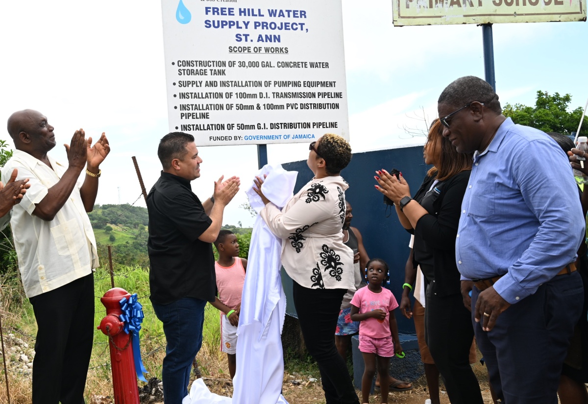 Minister without Portfolio in the Ministry of Economic Growth and Job Creation, Hon. Matthew Samuda (second from left), applaud the unveiling of the Free Hill Water Supply System signage at the official commissioning of the water infrastructure in St. Ann on Tuesday (July 29). He is joined by (l-r) Councillor for the Bamboo Division, Sydney Stewart; Member of Parliament, St. Ann North Western, Krystal Lee; Acting Managing Director of Rural Water Supply Limited (RWSL), Murie Bennett; and Regional Manager for the National Water Commission’s (NWC) North East region, Richard Williams.