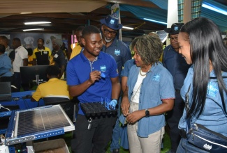 Minister of Education, Skills, Youth and Information, Senator Dr. the Hon. Dana Morris Dixon (centre), listens as Dihanroy Mitchell of the HEART/NSTA Trust highlight’s features of the agency’s technology display at the Denbigh Agricultural, Industrial and Food Show in May Pen, Clarendon on Friday (Aug. 1). The Minister is joined by the agency’s Managing Director, Dr. Taneisha Ingleton (right).