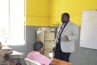 Principal of Adelphi Primary School in St. James, Marlon Campbell (right) speaks to students. 

