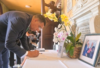Prime Minister, Dr. the Most Hon. Andrew Holness, signs the Condolence Book at the Mass of Christian Burial for the life of former Senator Don Wehby, at the Holy Trinity Cathedral in Kingston on Thursday (August 14).

