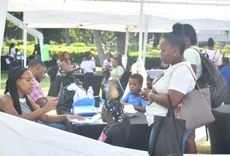 Volunteers (at left) register children during the Sandals back-to-school outreach initiative, held at Turtle River Park in Ocho Rios, St. Ann, on Monday (August 4).

